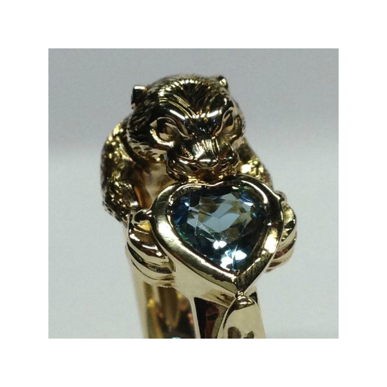 Closeup of otter and aquamarine ring in gold